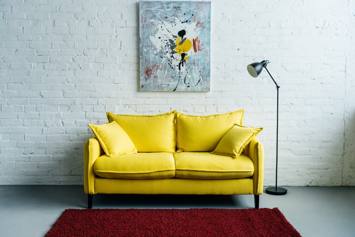 Yellow Couch and Maroon Rug in Living Space