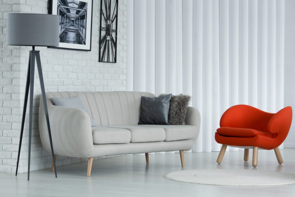 A Bright Orange Chair Placed With A Gray Sofa